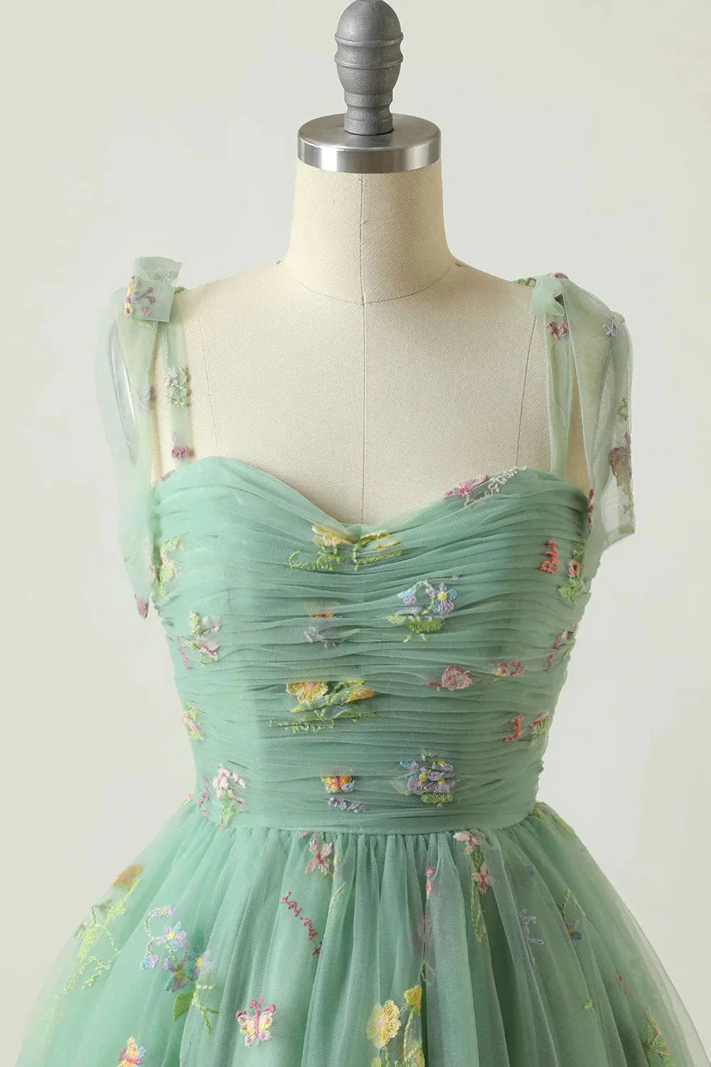 Vestido de fiesta corto color champán con tirantes finos y bordado en forma de A