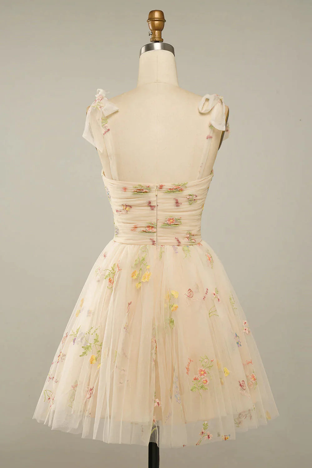 Vestido de fiesta corto color champán con tirantes finos y bordado en forma de A