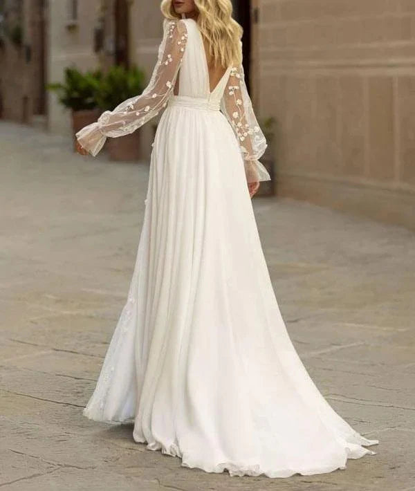Vestido de novia bohemio de manga larga, fluido, con encaje, escote en V, abertura frontal y cola larga.