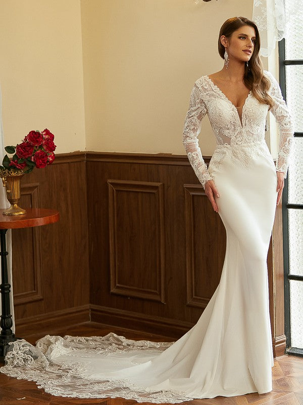Vestidos de novia con escote en V, mangas largas y cola catedral, de crepé elástico y encaje.
