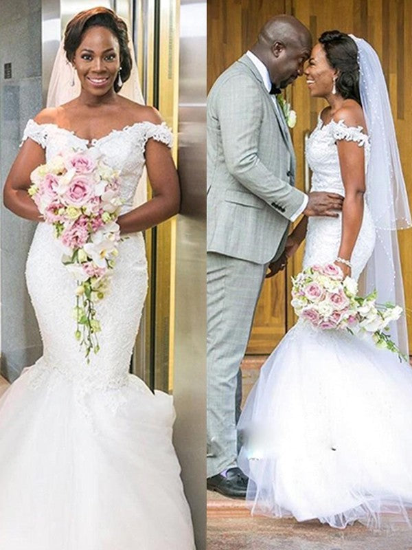 Vestidos de novia de tul con hombros descubiertos, apliques, sin mangas y cola larga.