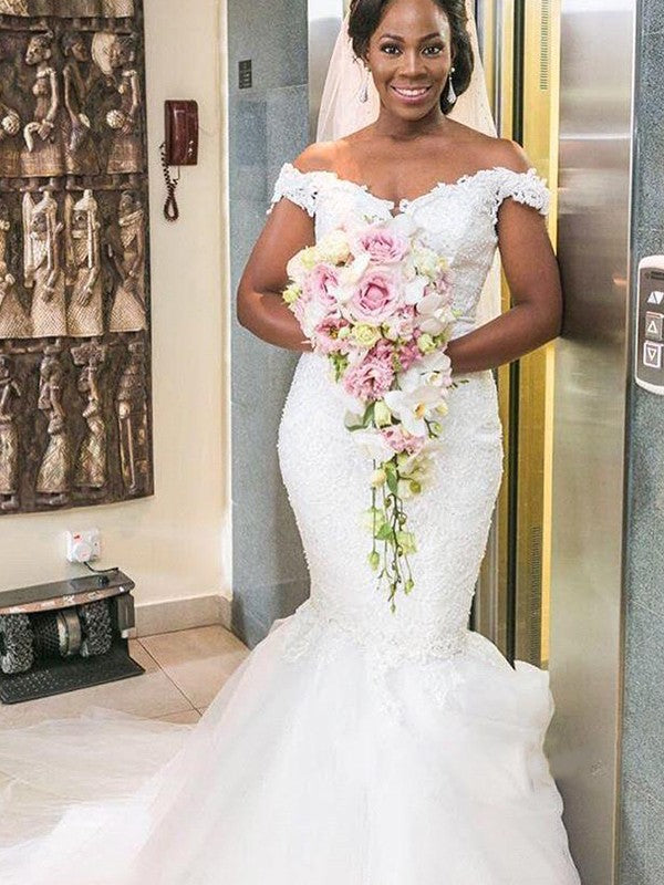 Vestidos de novia de tul con hombros descubiertos, apliques, sin mangas y cola larga.