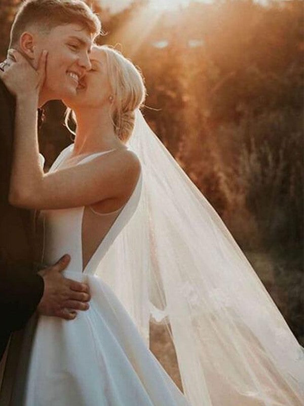 Vestidos de novia de satén con volantes, escote en V, sin mangas y cola larga.